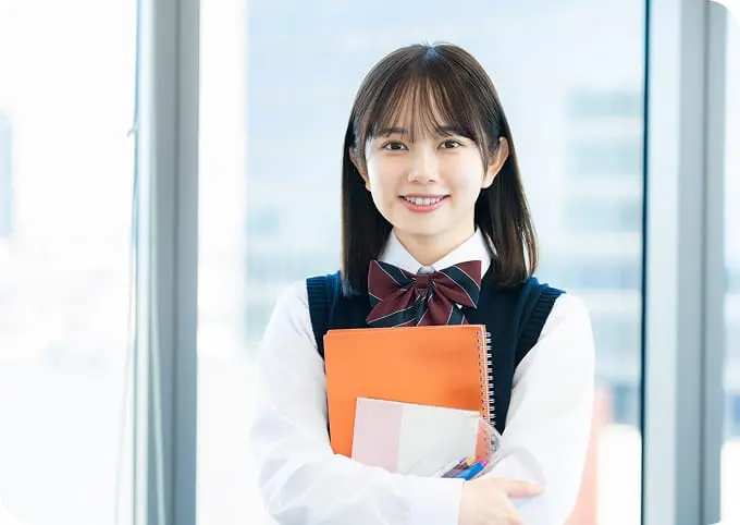 女子生徒が勉強道具を抱えて知識を身につけるイメージ