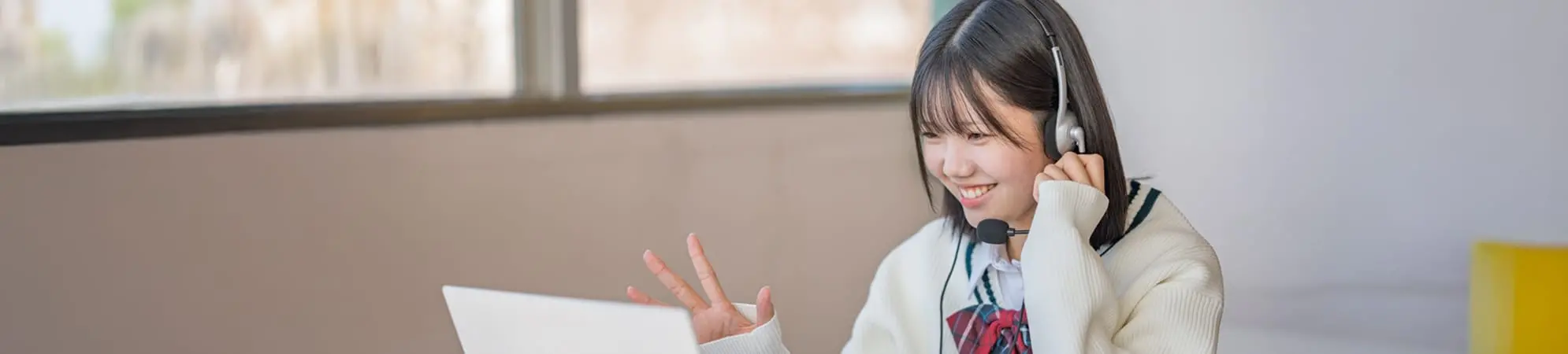 女子高校生がPCに向かって笑顔で会話する様子