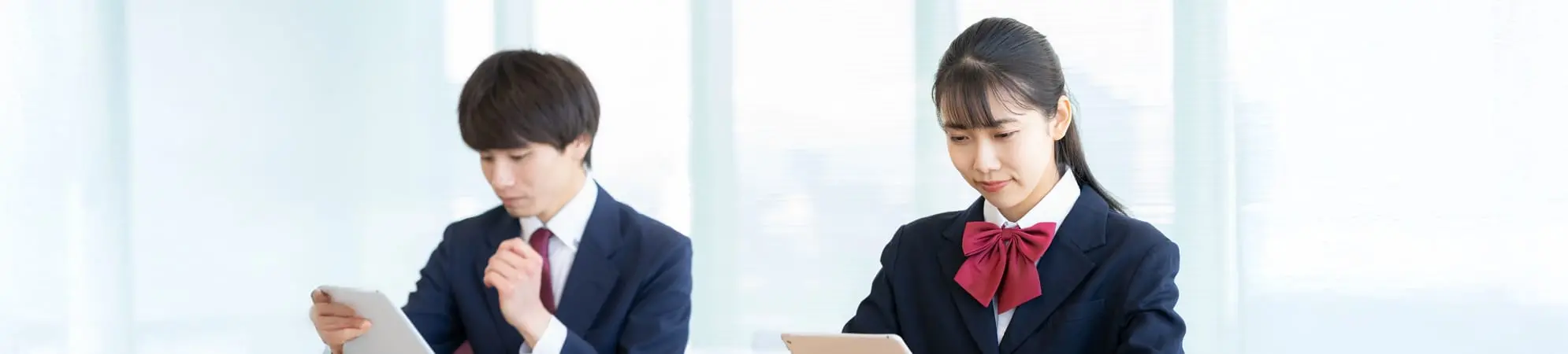 男女生徒がタブレットを使って勉強しています