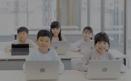 小学生の男女5名がタブレットやPCで楽しく勉強しています