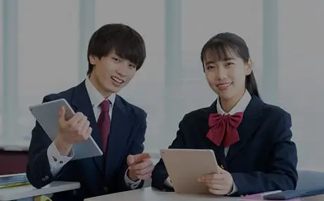 中学生の男女がタブレットで勉強しています